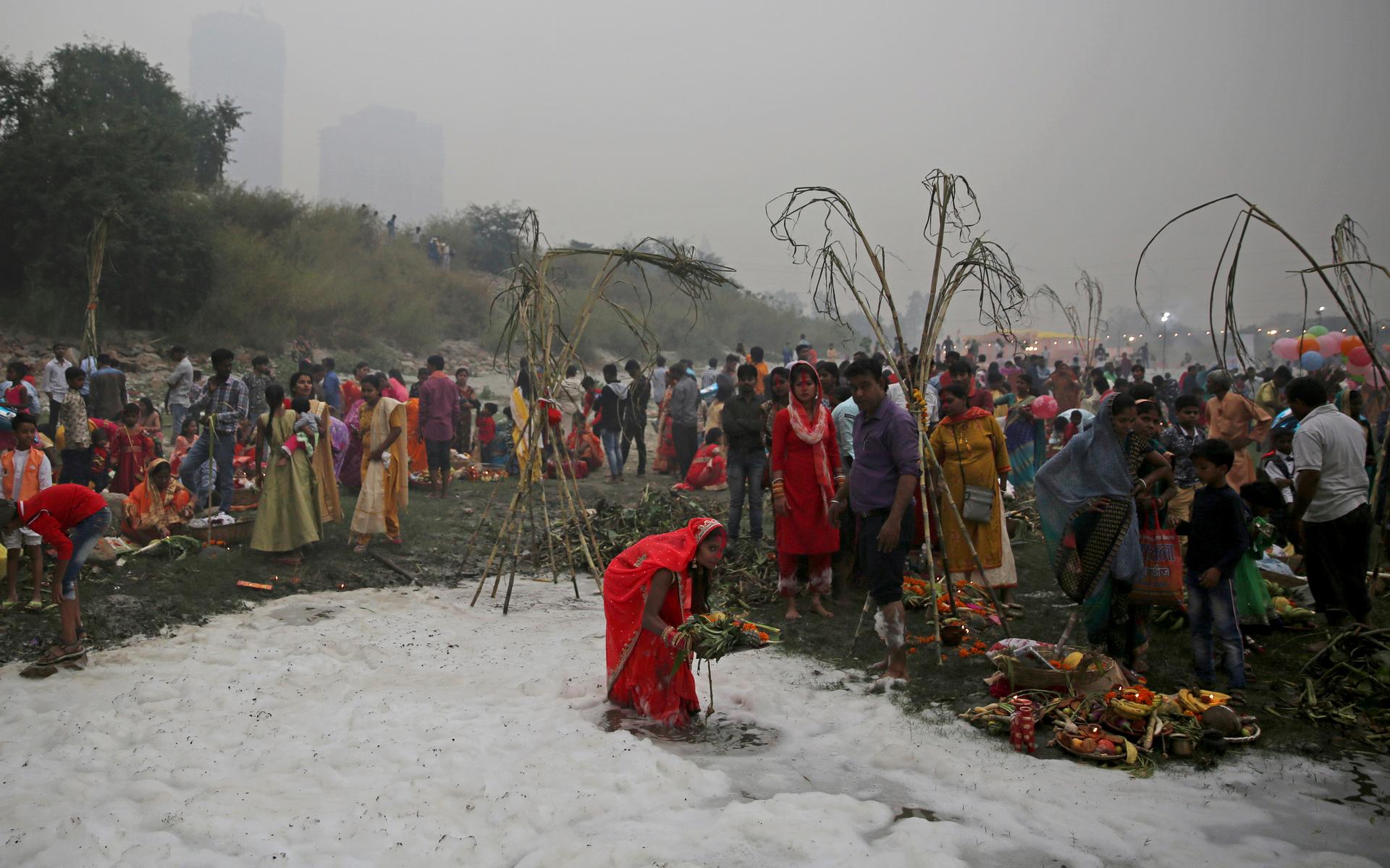 Tusentals hinduer tar sig till floden för att fira högtiden Chhath och badar då i det giftiga skummet.