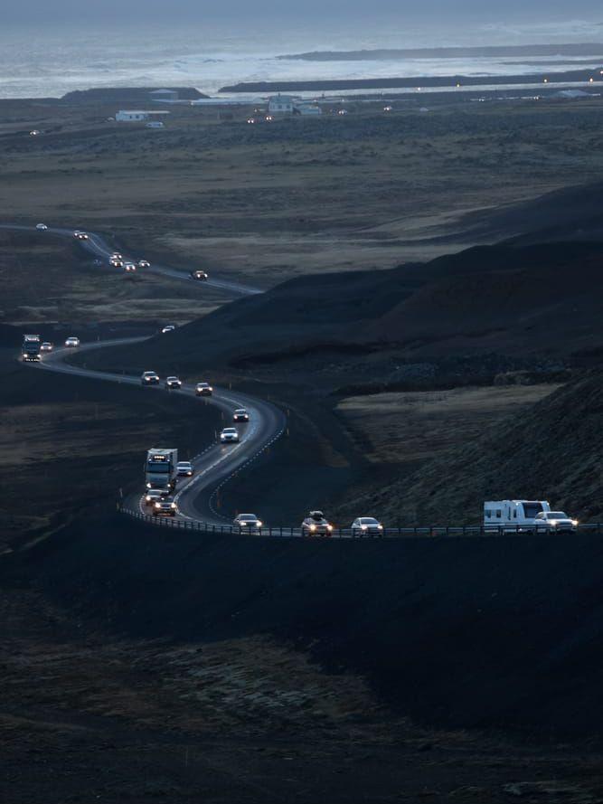 En rad bilar lämnar Grindavik på Island. 
