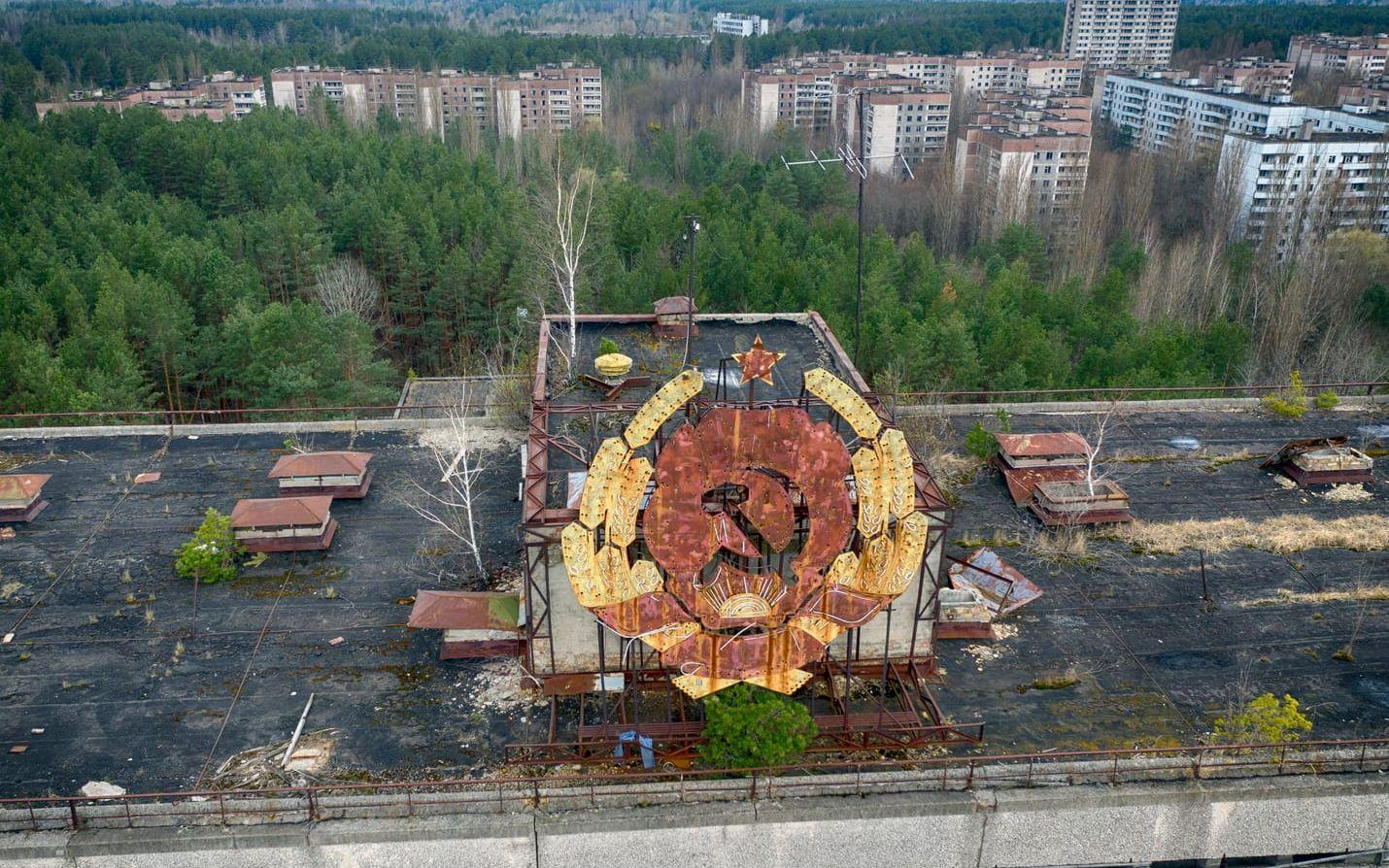 Sovjetunionens emblem sitter kvar på en byggnad i Pripjat. Regimens hantering av katastrofen och försöken att tysta ner den skyndade på Sovjetunionens sönderfall, enligt många experter.