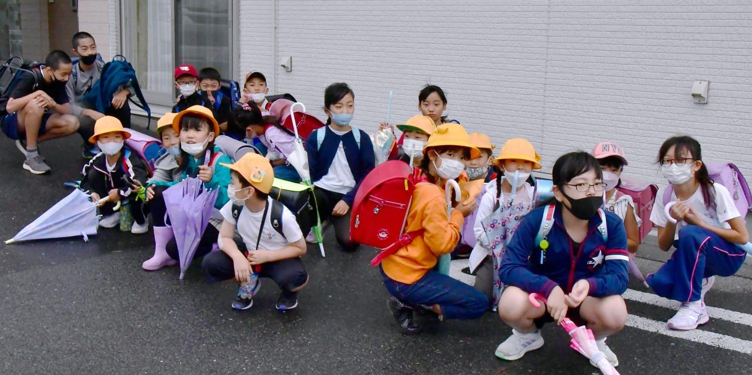 Barn på väg till skolan i Misawa i den japanska prefekturen Aomori tar skydd efter rapporterna om den nordkoreanska robotuppskjutningen.