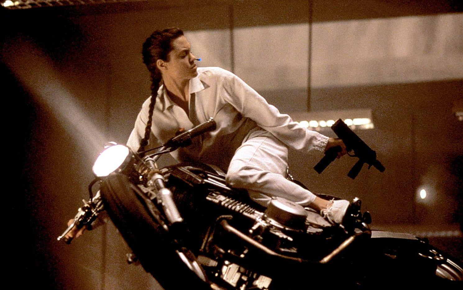 Angelina Jolie med en mycket lutad motorcykel. 