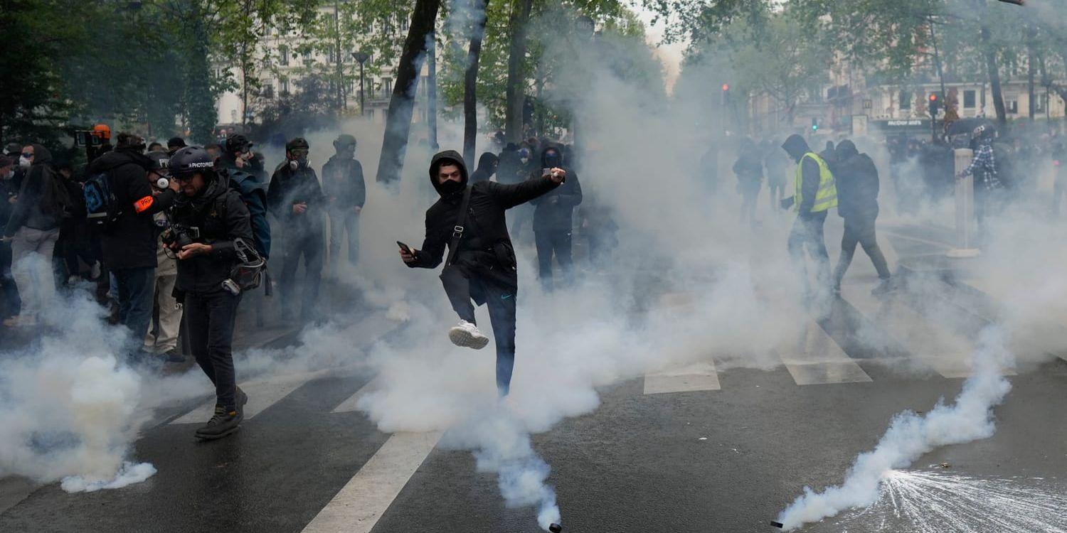 Unga demonstranter sparkar tillbaka polisens tårgaspatroner vid en demonstration i Paris.