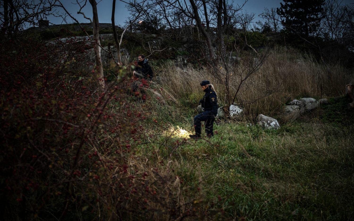 Poliser med ficklampor sökte av området kring brottsplatsen under torsdagseftermiddagen.