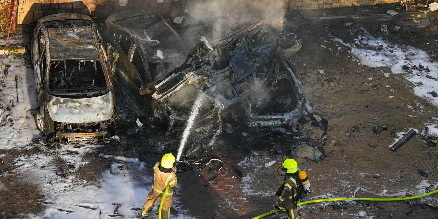 Räddningstjänsten släcker en brand efter det att en raket från Gaza slagit ned på en parkeringsplats i Ashkelon i Israel.