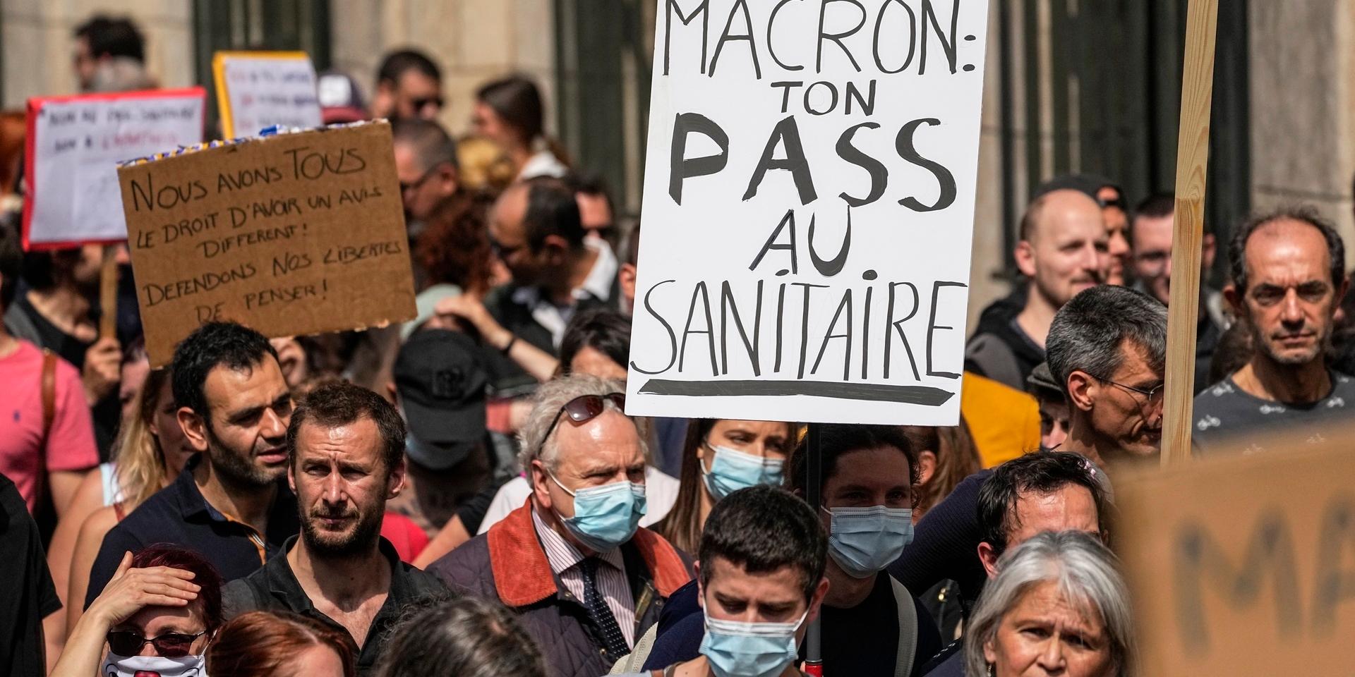 Parisdemonstranter uppmanar president Emmanuel Macron att kasta sitt hälsopass i toaletten den 17 juli.