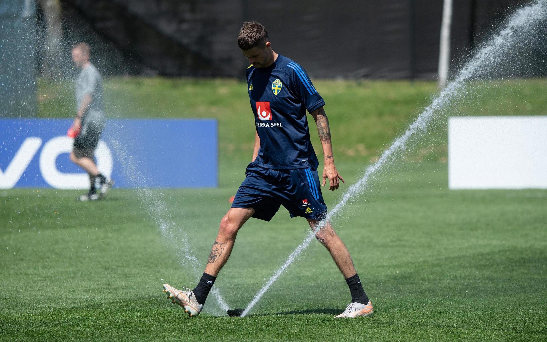 Mikael Lustig försöker få stopp på den sprinkler som gick igång just som landslaget skulle spela Sverige mot Sverige på onsdagens träning. 