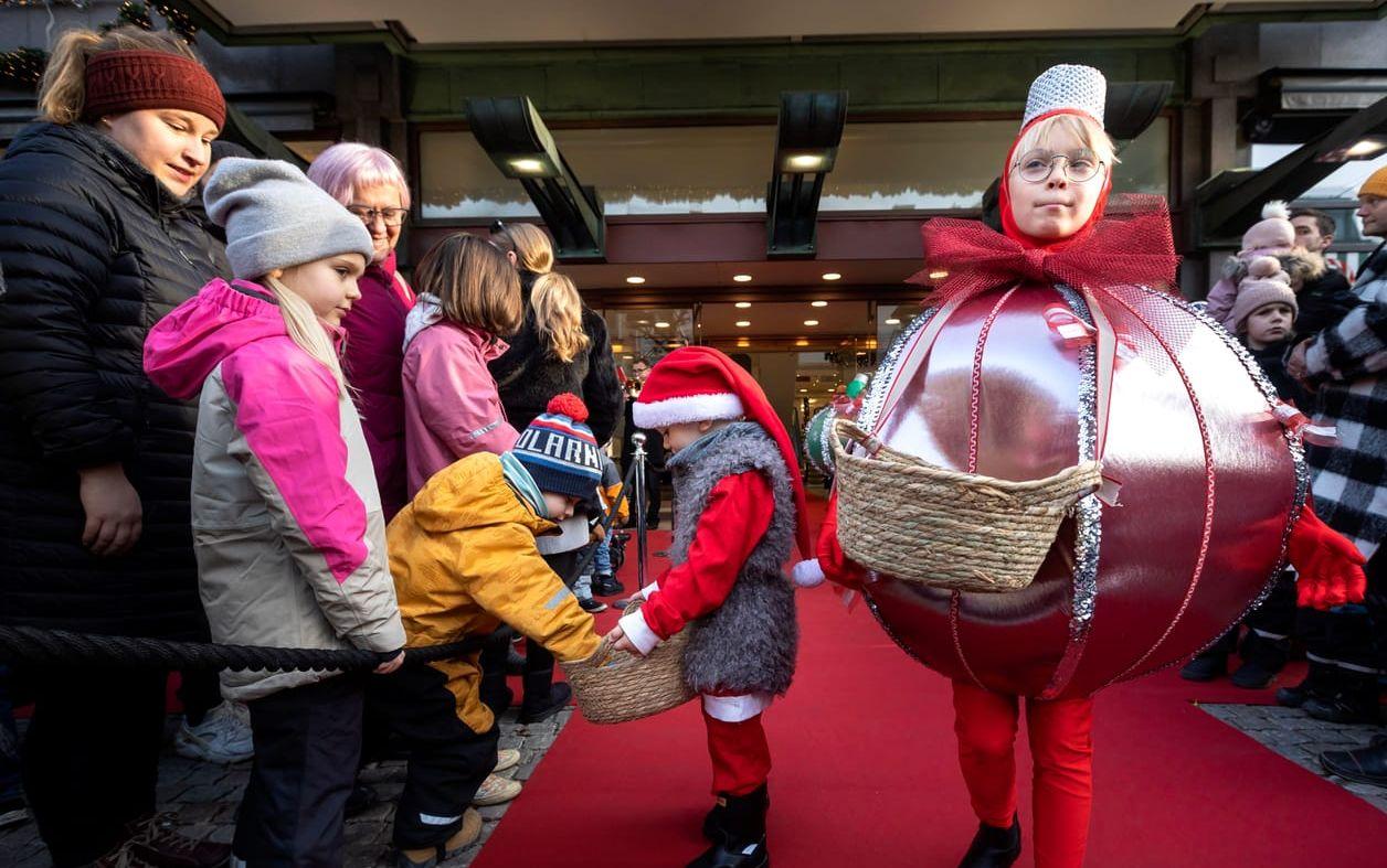 En genomgående och viktig detalj i årets julskyltning är tomtens hjälpredor, julkulorna. Här livs levande sådana  som delade ut godsaker till åskådarna i väntan på tomtens ankomst.